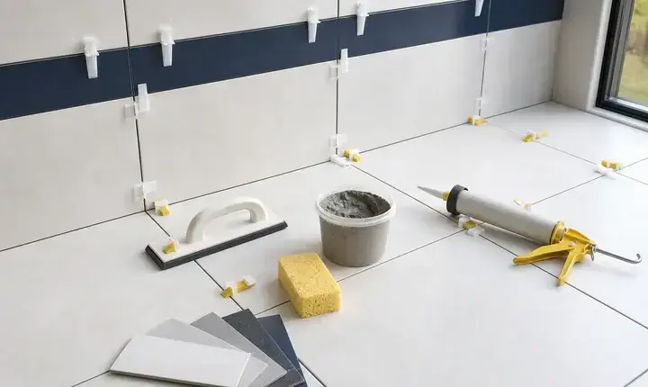 Carrelage et faïence: joints, croisillons et clips Joints et croisillons carrelage et faïence avec clips, mortier, éponge et carreaux alignés