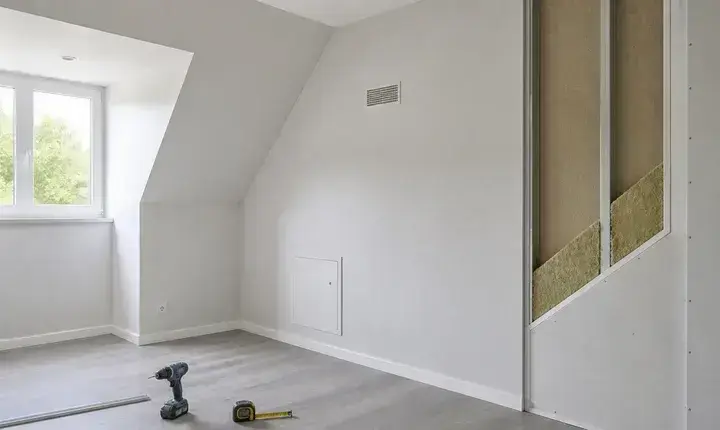 Finition adaptée isolation avec chambre finie, grille, trappe, placo propre et détail d'isolant visible