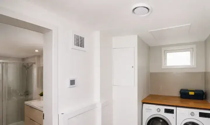 VMC et ventilation: finitions, bouches et accès Finitions VMC dans salle de bain avec bouche d'extraction, entrée d'air, trappe d'accès et capteur discret