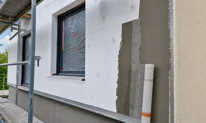 Solution standard isolation thermique extérieure avec panneaux, chevilles, trame, sous-enduit, échafaudage et fenêtre protégée